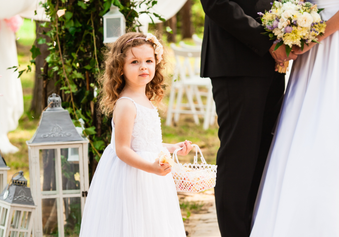 kleines Mädchen trägt dem Brautpaar in einem Körbchen etwas zum Altar