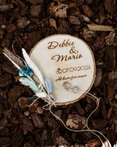 Ein Baumstammstück ist eingebrannt mit dem Datum des Hochzeitstages und der Namen des Brautpaares