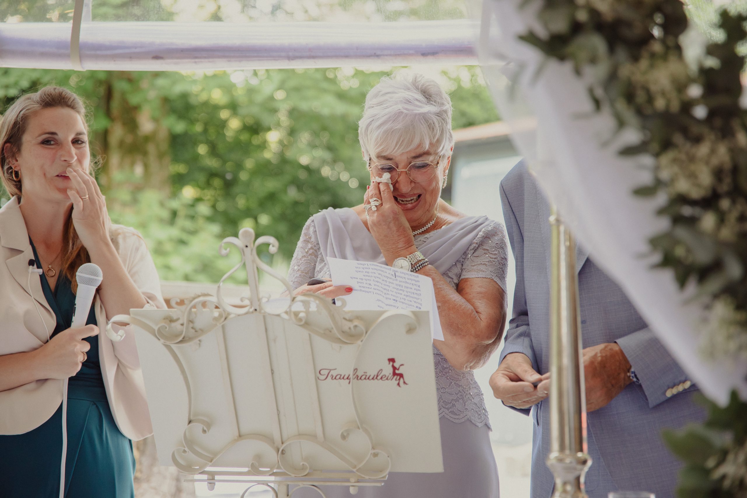 Die Mutter der Braut liest während der freien Trauzeremonie etwas vor und wischt sich dabei Freudentränen aus dem Gesicht