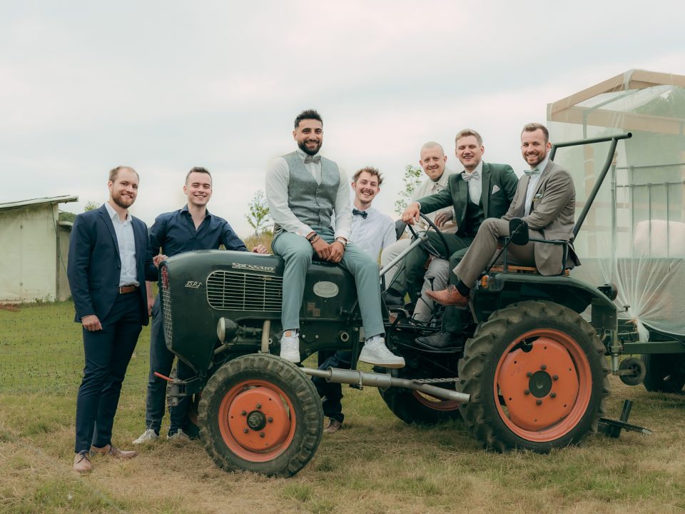 Bräutigam mit Freunden auf einem Traktor bei einer Bauernhofhochzeit in Solingen