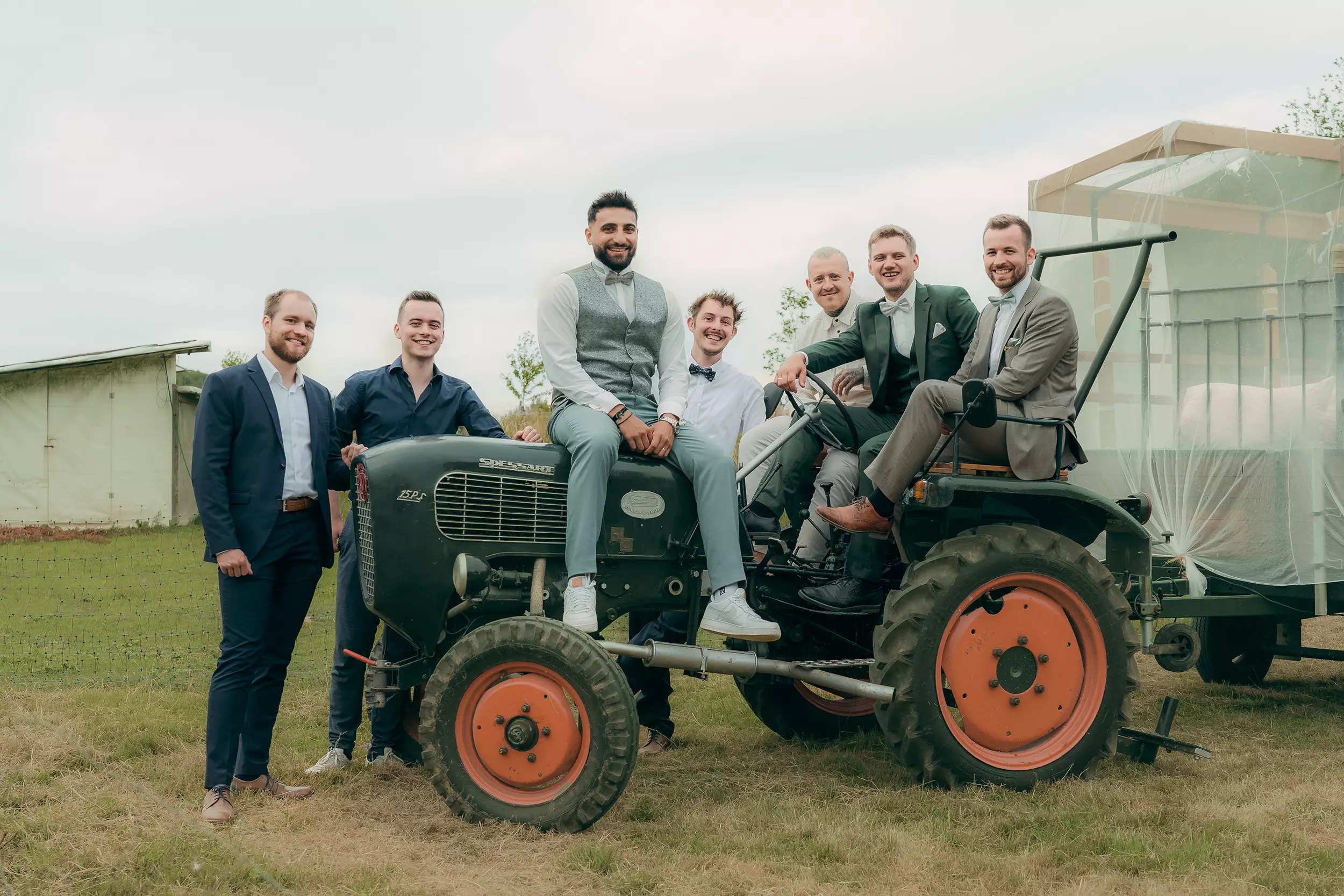 Bräutigam mit Freunden auf einem Traktor bei einer Bauernhofhochzeit in Solingen